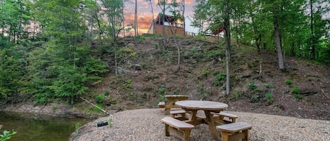 One of the two outdoor dining options is to take a short and easy walk to the picnic area with tables situated by your own private creek that burbles gently along the back of the property and is so crystal clear you can see fish.