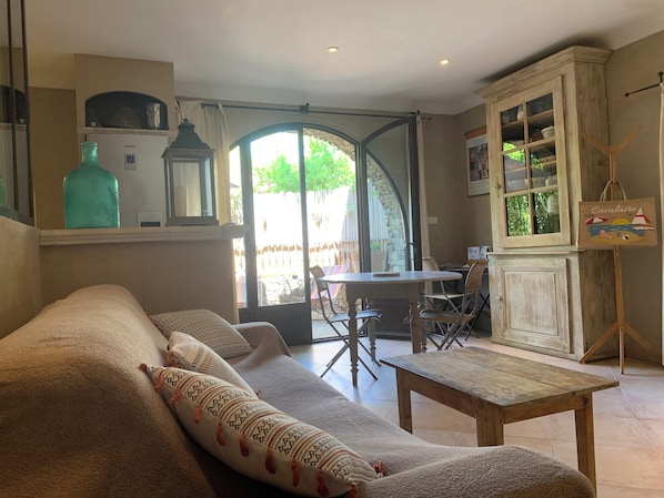 Salon avec canapĂ© lit qui donne directement sur lâextĂ©rieur