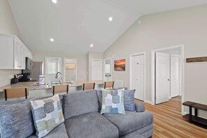 Your relaxation zone: Comfy sofa, stylish chair, entertainment-ready TV, outdoor deck, and a warm indoor fireplace.