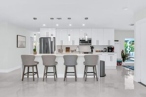 The dining area features a 6-person dining table perfect for your group feasts. There are 4 additional counter stools at the impressive quartz waterfall island.