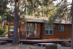 This large cabin features three bedrooms, two with a queen-sized bed and the other with two twin beds, a living room with a sofa bed, and a full kitchen with a microwave, fridge, and Keurig coffee maker.