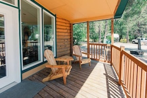 The lovely covered porch with a picnic table is a great place to enjoy a meal outdoors, surrounded by the fresh air and greenery. The porch is covered by a wooden roof that protects you from the sun and the rain. The picnic table is large enough to seat up to six people and has a bench on each side