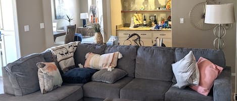 Living area with large TV next to open dining room and reading area.