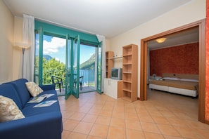 Wohnzimmer mit Zugang zum Balkon und Schlafzimmer mit Doppelbett