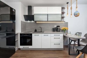 A sleek kitchen with black and white cabinetry, equipped with high-quality appliances and ample counter space.

