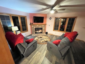 Fireplace room: couch and loveseat with 2 recliners on each, fireplace, tv