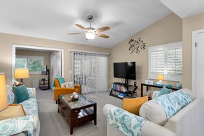 View of Living Room from Dining Room; view of enclosed porch that leads to patio