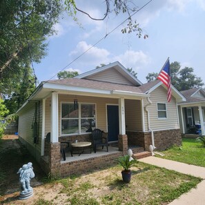 Front porch w two chairs and table.