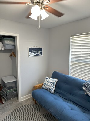 Linens and pillow in closet bins with luggage rack