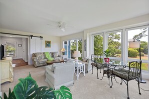 The first floor has a living room, and covered porch with table and chairs.