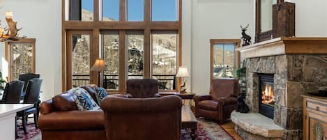 Cozy Up by the Fire in this Gorgeous Two Story Living Room with Sweeping Mountain Views.