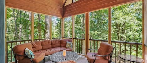 Relax in this beautiful screened in sitting porch to enjoy the outdoors comfortably.