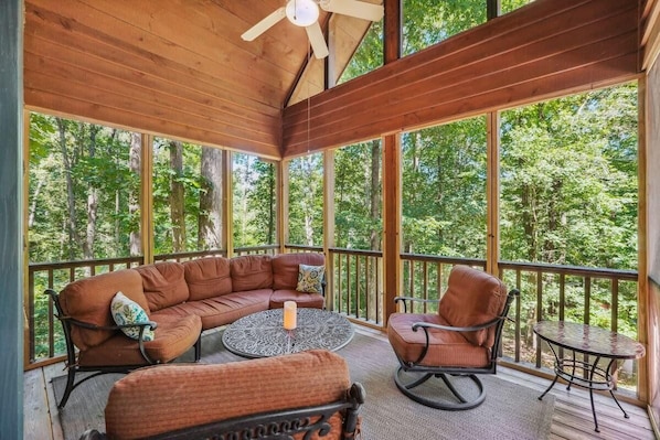 Relax in this beautiful screened in sitting porch to enjoy the outdoors comfortably.