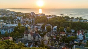 Panoramic view capturing a breathtaking sunset over the town and coastline, perfect for enjoying scenic evenings.

