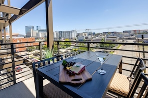 Balcony / Patio accessible through the living room and primary bedroom featuring outdoor furnishings for dining and lounging accompanied with city views.