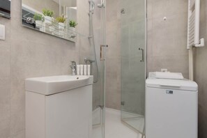 Bathroom with a shower, toilet and washing machine.