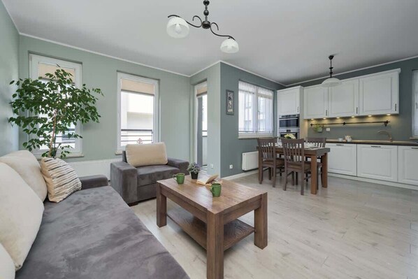 Spacious living area with a modern sofa, wooden coffee table, and a calming color palette that creates a cozy ambiance.

