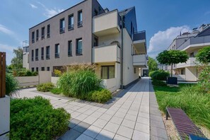 Exterior view of the modern property surrounded by a well-maintained garden and a paved walkway.

