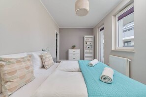 Bright and elegant bedroom featuring a comfortable bed with fresh linens and soft decorative accents.


