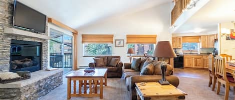 Living room with gas fireplace, flatscreen TV, and access to balcony.