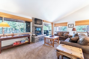 Living room with gas fireplace, flatscreen TV, and access to balcony.