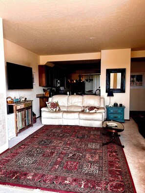Great Living room with two leather reclining couches and a extra large recliner.