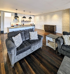 Living room with kitchen in background 
. You can also see the murphy bed.