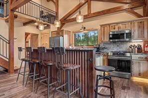 A gleaming kitchen countertop and well-stocked kitchen adorned with modern appliances and tasteful accents, stands ready for culinary creations