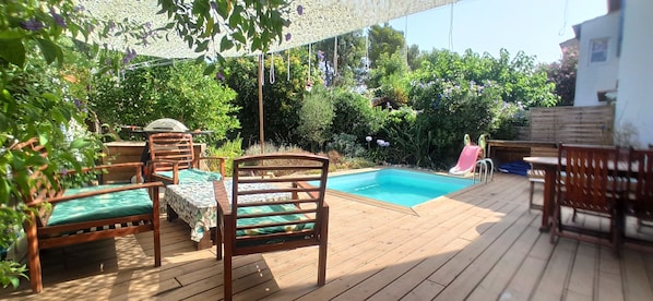 Terrasse n°2 avec piscine, transats, table et chaises, et salon d'extérieur.