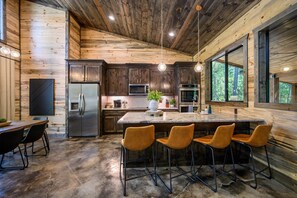 Open kitchen with dining table and seating at the island.