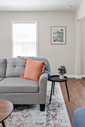 Experience the luxurious comfort of our strikingly soft sofa, complemented by elegantly decorated walls and a window offering a natural view from within.