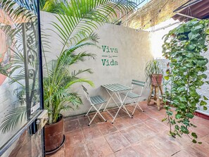 Private terrace with dining set and lush plants