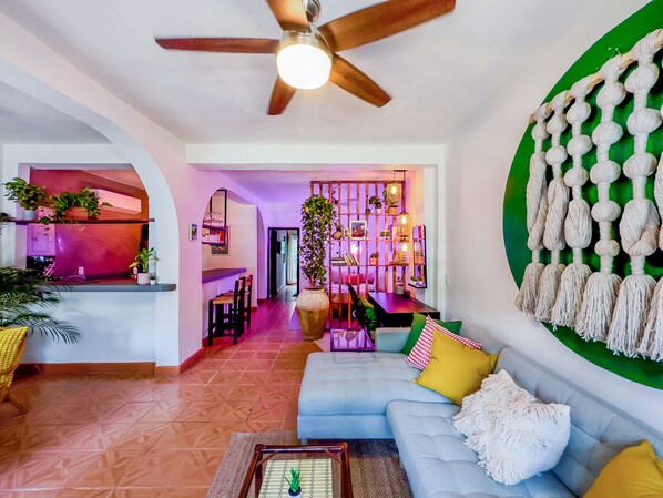 Open concept living area with lots of natural light and lush plants