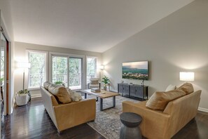 Natural light floods through windows with tree-lined views. 