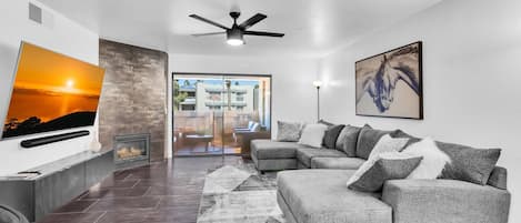 Living room has 65" Smart TV with Cable, sectional sofa & fireplace
