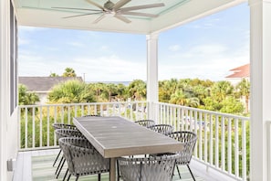 The top level covered balcony with outdoor dining for 8