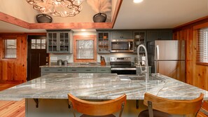 Elegant Oversized Island Countertop Overhang with Stools for Casual Dining.