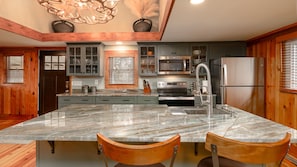 Elegant Oversized Island Countertop Overhang with Stools for Casual Dining.