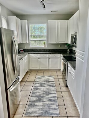 Spacious kitchen with stainless steel appliances and lots of natural lighting