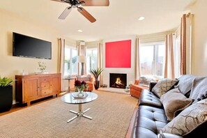 Living room with flat screen TV and fireplace.