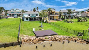 Enjoy the spacious yard and large deck  at your scenic waterfront retreat. 