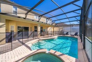 From your shaded lounge, gaze out at the expansive, crystal-clear pool, surrounded by a stylish screen for added privacy.