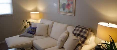 Beautiful, plush living room with overstuffed couch, cozy blankets and smart tv!