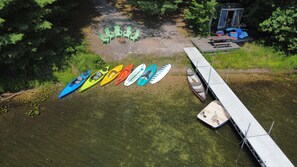 OVERALL:  An aerial photo of the private lakefront showing the dock, bonfire ring, kayaks, paddleboards, canoe, and pedal boat.