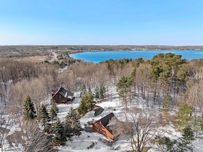 EXTERIOR:  An aerial view of the cabin with Crystal Lake in the background.