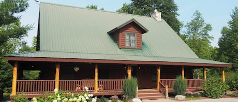 EXTERIOR:  The front of the cabin in summer