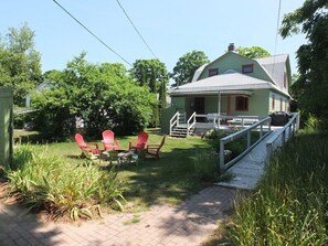 EXTERIOR:  The back of the house showing the back porch, ramp, backyard, and fire pit.