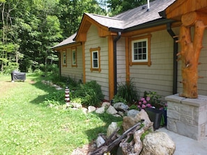 EXTERIOR: A closer view of the front of the house. The outdoor propane gas grill that is available for guests to use is shown in the photo as well.