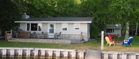 OVERALL:  The front of the cottage on Little Glen Lake, highlighting the lake, lakefront deck, private dock, and the bonfire ring.