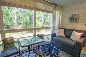 Sapphire Seascape features a screened porch with a dining table, loveseat and half bathroom.